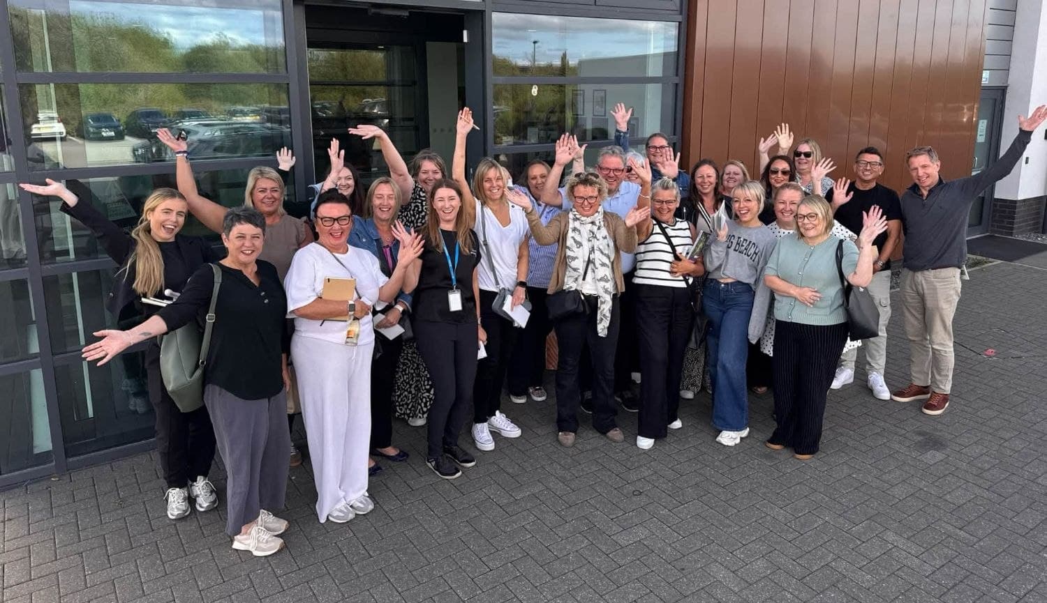 The Premier Travel team outside the office, waving